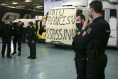 Des gendarmes se tiennent à côté de leurs camions sur lesquels a été déployée une banderole "L'Etat français assassin", le 4 mars 2022 à Ajaccio