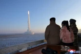 Le numéro un nord-coréen Kim Jong Un (gauche) et sa fille (centre) assistent à un lancement d'essai d'un missile balistique intercontinental, le 19 décembre 2023 dans un lieu inconnu de Corée du Nord, selon cette photographie publiée par l'agence officielle KCNA