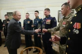 Photo transmise par l'agence officielle russe Sputnik montrant le président Vladimir Poutine portant un toast avec des militaires des forces armées russes, le 1er janvier 2024 à Novo-Ogaryovo, près de Moscou  