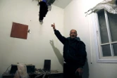 Un homme montre les dégats provoqués dans son domicile par une roquette tirée depuis la bande de Gaza, le 25 mars 2019 au soir, dans la ville israélienne de Sdérot