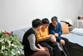 Zhang Yachun (c), entourée de son père et de sa mère, parle avec son robot Aluo, doté d'une intelligence artificielle, le 7 janvier 2025 à Pékin