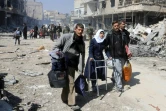 Une adolescente syrienne s'appuie sur un déambulateur pendant son évacuation de la ville de Jisrine dans le sud de la Ghouta orientale, en direction de zones sous contrôle gouvernemental, le 17 mars 2018 