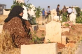 Des Syriens sur les tombes de membres de leur famille au premier jour de l'Aïd al-Adha, la grande fête musulmane du sacrifice, le 1er septembre 2017 à Binnish (Syrie)