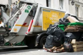 Un camion-poubelle passe à côté de poubelles débordantes de déchets à Paris le 8 juin 2016