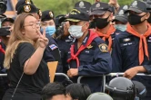 Panusaya "Rung" Sithijirawattanakul (g), une leader du mouvement pro-démocratie, devant des policiers à Bangkok, le 20 septembre 2020
