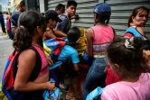Des gens se battent pour récupérer de la nourriture sur le sol d'un marché de rue à Caracas, le 10 mars 2019