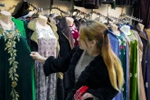 Une femme regarde des vêtements nationaux dans une boutique du bazar Korvon, à Douchanbé, le 2 décembre 2024 au Tadjikistan