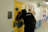 Un agent pénitentiaire regarde par le judas d'une porte à l'intérieur d'une cellule    de l'Unité pour détenus violents de la prison de Fleury-Mérogis, le 21 juin 2023 dans l'Essonne