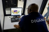 Un douanier français scanne le bagage d'un passager se rendant à Paris à l'aéroport international Félix-Eboué de Cayenne, le 24 mars 2024