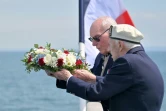 Des vétérans britanniques se préparent à jeter une gerbe de fleurs dans la mer depuis le pont d'un ferry lors d'une cérémonie au large de Portsmouth, le 4 juin 2024, dans le cadre des commémorations du « jour J »