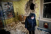 Une femme se tient au milieu des débris dans une école bombardée à Stanitsa Louganska, dans l'Est de l'Ukraine, le 17 février 2022
