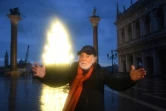 L'artiste italien Fabrizio Plessi pose devant son installation lumineuse évoquant un sapin de Noël sur la place Saint-Marc à Venise le 4 décembre 2020