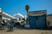 Des Palestiniens passent devant le siège endommagé de l'Office de secours des Nations Unies pour les réfugiés de Palestine (Unrwa) à Gaza-ville, le 15 février 2024
