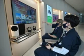 Dans un magasin d'électronique à Séoul, des vendeurs jouent sur grands écrans avec la Xbox Series X de Microsoft, le 10 novembre 2020