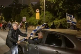 Un automobiliste s'emporte contre un manifestant anti-guerre et anti-gouvernement qui bloque avec d'autres une autoroute à Tel-Aviv, le 13 janvier 2024
