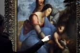 Des visiteurs regardent la "La Vierge et l'enfant avec Sainte Anne"  de Léonard de Vinci au Louvre le 23 mars 2012