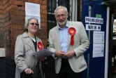 Le chef de l'opposition travailliste  Jeremy Corbyn parle avec une militante devant un bureau de vote le 3 mai 2018 à Londres.