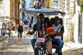 Un Cubain, chauffeur de taxi à trois roues, porte un t-shirt aux couleurs du drapeau américain, le 9 novembre 2016 dans une rue de La Havane 