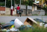Des jeunes passent devant des ordures à Kourou en Guyane, le 3 avril 2017