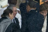 Le président américain Barack Obama serre la main du président cubain Raul Castro lors des obsèques de Nelson Mandela, dans le stade de Soweto, le 10 décembre 2013 à Johannesburg, en Afrique du Sud