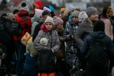 Des réfugiés attendent des cars du côté polonais de la frontière avec l'Ukraine, à Medyka,  le 6 mars 2022