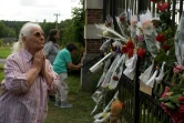 Une femme rend hommage à des personnes qui déposent des fleurs devant l'entrée de la propriété de l'acteur français Alain Delon, à Douchy, dans le centre de la France, le 18 août 2024