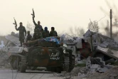 Des forces progouvernementales syriennes brandissent leurs armes après être entrées dans la localité de Chifouniya, dans la Ghouta orientale, le 4 mars 2018
