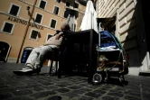 Un SDF dort dans une rue déserte de Rome, le 1er avril 2020 en Italie