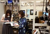 Yuriko Yamada (d), participante à une promenade photographique à Kamakura, regarde ses tirages avec une amie dans un magasin d'appareils photos à Yokohama, le 29 juin 2024 au Japon