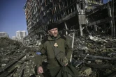 Un prêtre militaire parmi les débris du centre commercial Rettroville, à Kiev le 21 mars 2022
