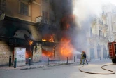 Des pompiers s'emploient à éteindre le feu dans une banque provoqué par des manifestants à Tripoli, dans le nord du Liban, le 28 avril 2020 