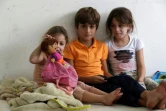 Trois des enfants du Libanais Moustafa al-Sayyed qui a fui son village avec sa famille, assis dans une salle de classe d'une école à Tyr dans le sud du Liban, transformée en refuge pour les déplacés, le 19 octobre 2023