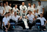 Le Britannique Lewis Hamilton (c) pose, entouré des membres de l'écurie Mercedes, sur le circuit de Yas Marina à Abou Dhabi, le 28 novembre 2019