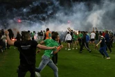 Des supporters ont envahi la pelouse du stade Geoffroy-Guichard et lancé des fumigènes à l'horizontale après le barrage perdu dimanche soir par Saint-Étienne contre Auxerre (1-1/1-1, 5 t.a.b. à 4), qui relègue les Verts en Ligue 2.