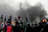 Des manifestants palestiniens lancent des pierres et incendient des pneus lors du premier anniversaire des "Grandes marches du retour", le long de la barrière frontalière entre la bande de Gaza et Israël, le 30 mars 2019 à l'est de Gaza city