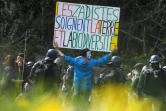 Un manifestant tient une pancarte face aux forces de l'ordre sur le site de la Zad de Notre-Dame-des-Landes, le 15 avril 2018  
