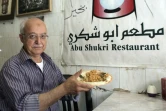 Yasser Taha, patron du restaurant palestinien Abou Choukri, pose avec une assiette de houmous, le 12 septembre 2015 à Jérusalem