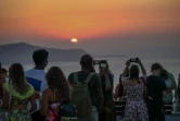 Des touristes attendent le coucher du soleil dans le village d'Oia sur l'île grecque de Santorin, le 20 juillet 2024