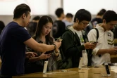 Des personnes regardent l'iPhone X en vente dans une boutique Apple, le 3 novembre 2017 à Hong Kong