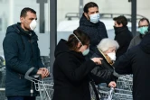 Des personnes portant des masques de protection vont faire leurs courses dans un supermarché, le 23 février 2020 à Caslpusterlengo, en Italie
