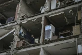 Un homme dans un appartement d'un immeuble détruit par un bombardement russe, le 25 mars 2022 à Kharkiv, en Ukraine