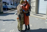Un soldat ukrainien embrasse sa femme  dans le centre d'Odessa, en Ukraine, le 17 mars 2022
