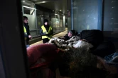 Des volontaires des Restos du Coeur parlent avec un sans-abri à Strasbourg, où la température est descendue à -7 degrés en soirée le 26 février 2018