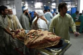 Une personne blessée pendant le séisme est accompagnée par ses proches à l'hôpital de Peshawar, le 26 octobre 2015 au Pakistan