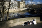 Un homme sans-abri dort le long d'un trottoir surplombant la Seine, à Paris, le 28 décembre 2017