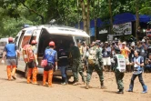 Des équipes de secours lors d'un exercice d'évacuation sur une route boueuse menant à la grotte de Tham Luang où sont piégés douze enfants et leur entraîneur de foot, le 30 juin 2018 à Chiang Rai, en Thaïlande