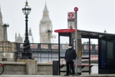 Un homme porte un masque de protection contre le Covid-19 à un arrêt de bus, le 16 février 2022 à Londres