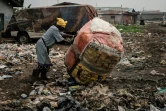 Une femme pousse un sac contenant des bouteilles de plastique recyclées, le 12 février 2019 dans un quartier de Lagos, au Nigeria
