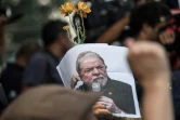 Un partisan de Lula arbore une photo de l'ex-président le 7 avril 2018 au cours d'une messe à la mémoire de son épouse.