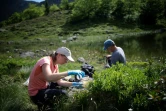 Dirk Schmeller, enseignant-chercheur et Pauline Benzi, étudiante, analysent des échantillons d'eau prélevés dans le lac Labant, le 23 juin 2022 à Aulus-les-Bains, en Ariège